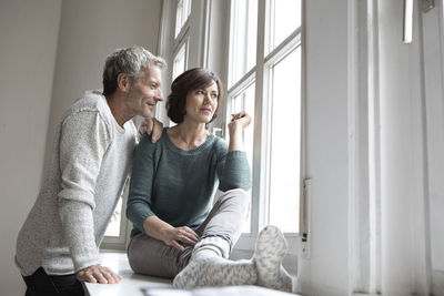 Mature couple looking out of window