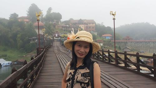 Portrait of smiling mature woman standing on footbridge