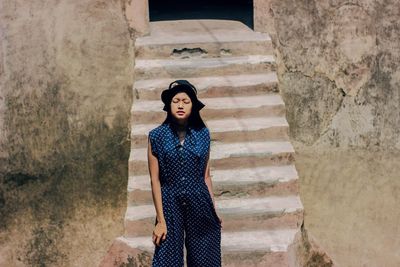 Portrait of woman standing against wall