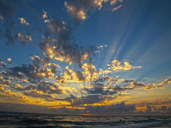 Scenic view of sea against dramatic sky during sunset