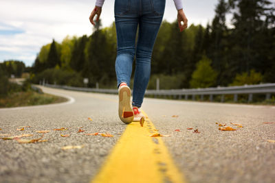 Low section of person with umbrella on road