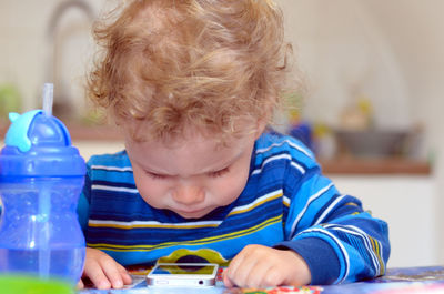 Portrait of boy holding table at home