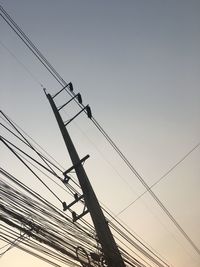 Low angle view of electricity pylon against clear sky