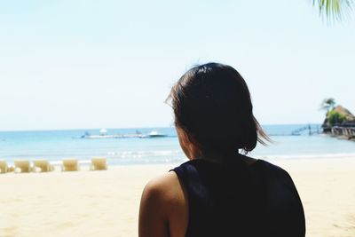 Rear view of woman looking at sea against clear sky