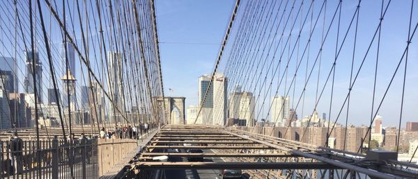 Low angle view of suspension bridge against sky