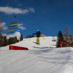 People skiing on snow covered mountain against sky