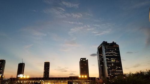 Low angle view of illuminated buildings against sky during sunset