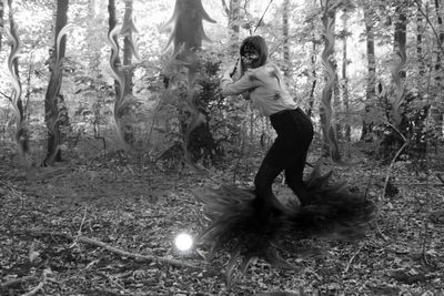 People standing on tree trunk in forest