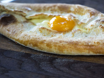 High angle close-up of khachapuri served in plate on wooden table