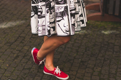 Low section of woman standing on street