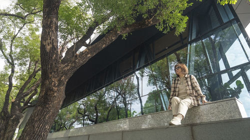 Low angle view of woman sitting on the wall