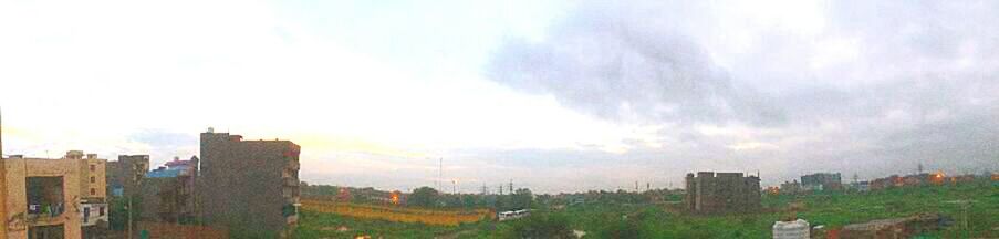 View of field against cloudy sky