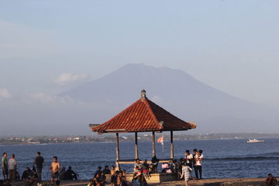 People at beach against clear sky