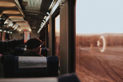 Rear view of man seen through train window