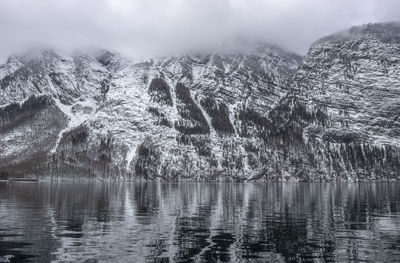 Scenic view of lake by mountains against sky