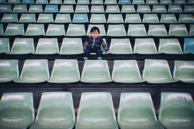 Full length of boy sitting on seat