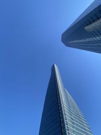 Low angle view of modern buildings against blue sky