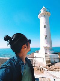 Portrait of man with lighthouse against sky