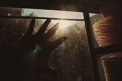 Close-up of hand on window