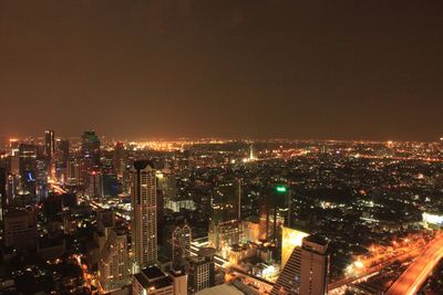 High angle view of illuminated buildings against sky at night