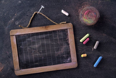 Directly above shot of writing slate with chalks on table