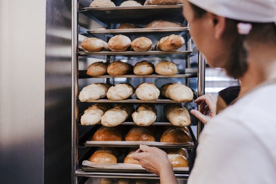 Close-up of woman by food in trays at bakery