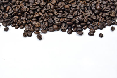 High angle view of coffee beans against white background