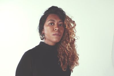 Portrait of young woman against white background