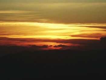 Silhouette of mountain range against dramatic sky