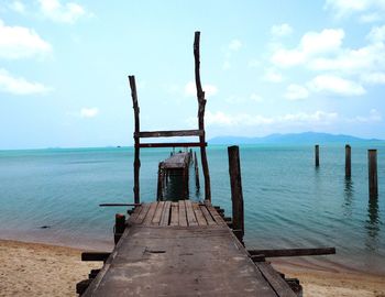 Pier on sea against cloudy sky