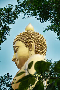 Low angle view of statue against trees