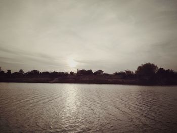 Scenic view of lake against sky at sunset