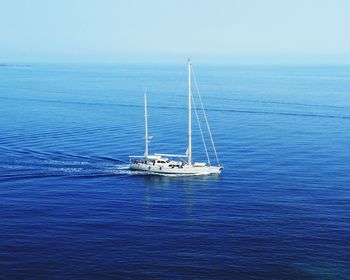 Sailboat sailing in sea against clear sky