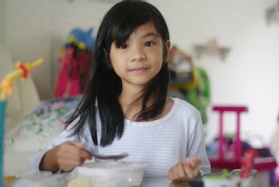 Portrait of woman holding ice cream at home