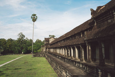 Temple amidst trees on field against sky