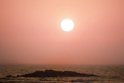 Scenic view of sea against orange sky