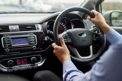 Cropped hand of man driving car