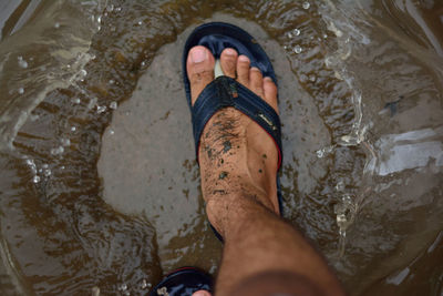 Low section of man standing in water