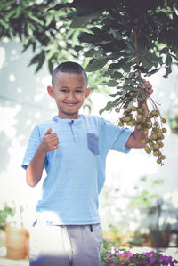 Portrait of boy standing against christmas tree