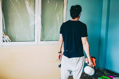 Rear view of man standing against wall