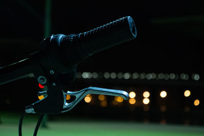 Close-up of illuminated lighting equipment on cable at night