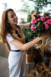 Portrait of young woman standing amidst flowers