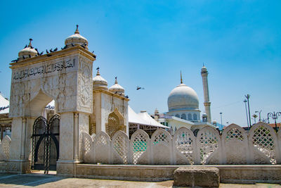 Low angle view of mosque against clear blue sky