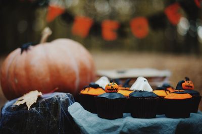 Close-up of cupcakes and pumpkin during halloween celebration