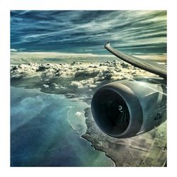 Airplane flying over sea against sky