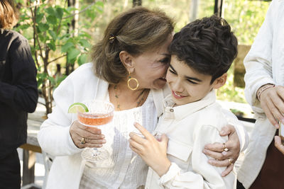 Happy senior woman hugging grandson at back yard