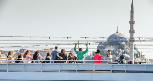 Group of people outside building against clear sky