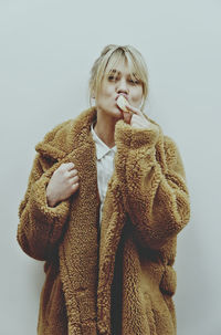 Young woman standing against white background