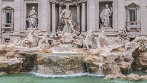 Statue of fountain in front of historical building