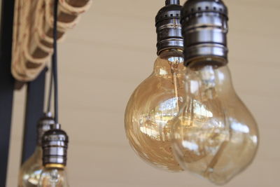 Close-up of light bulb hanging at home